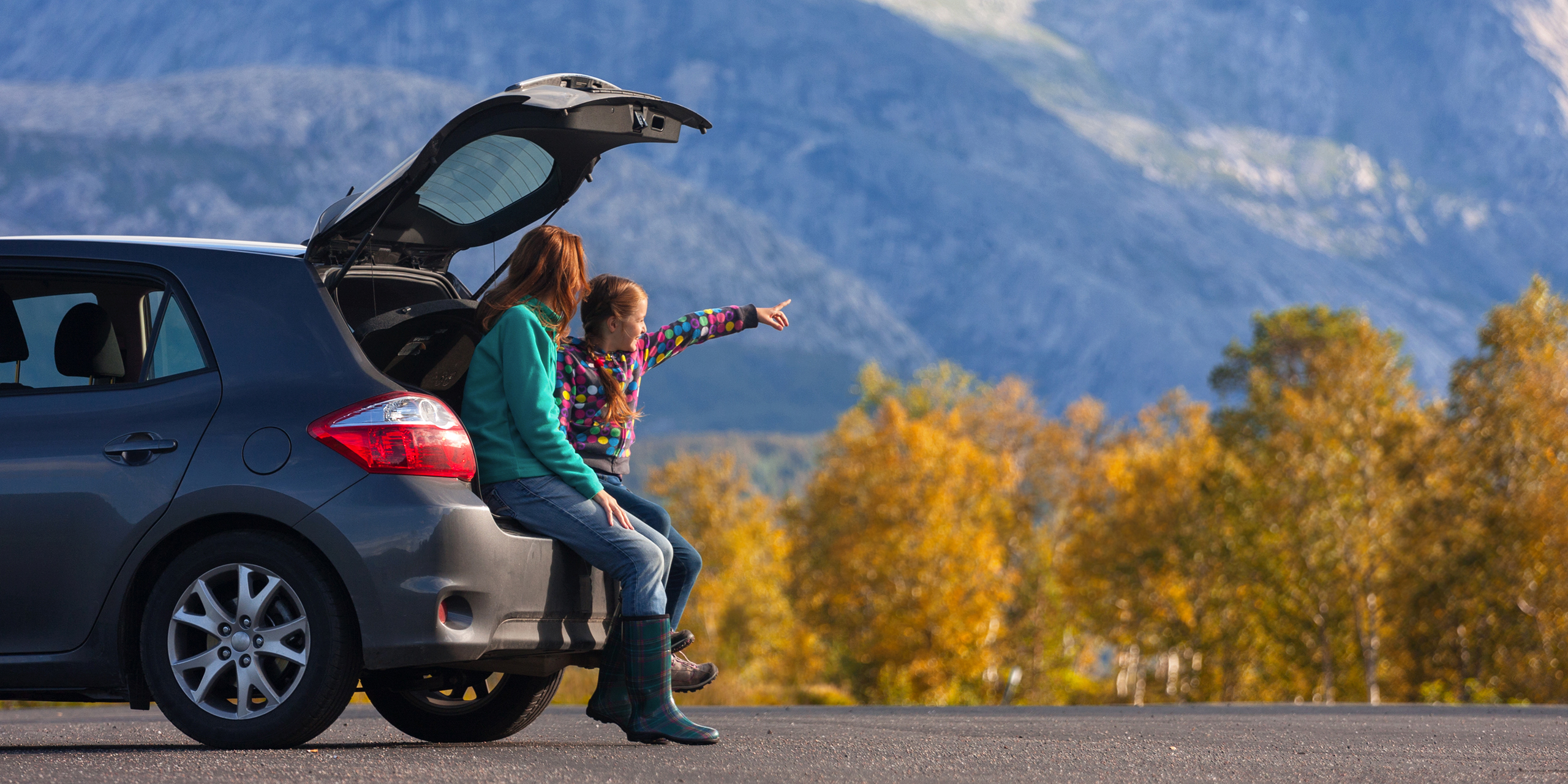 Mother and Daughter in SUV in Mountains; Courtesy of Mostovyi Sergii Igorevich/Shutterstock.com