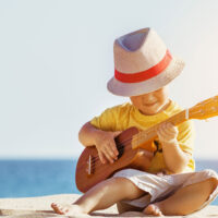 Little Boy Playing Ukulele in Hawaii; Dmitry Molchanov/Shutterstock.com