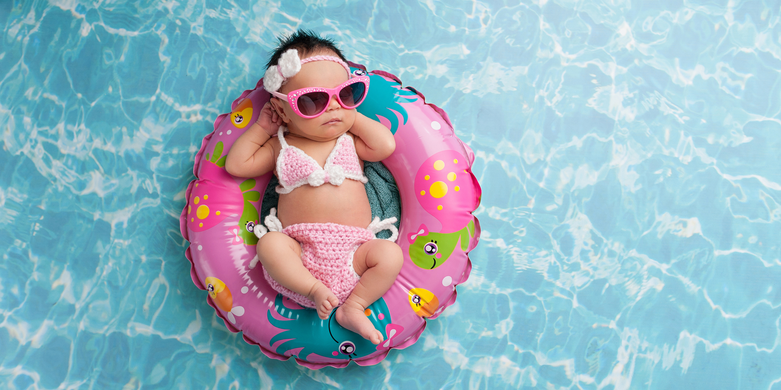 Infant Floating in Pool Wearing Sunglasses; Courtesy of Katrina Elena/Shutterstock.com