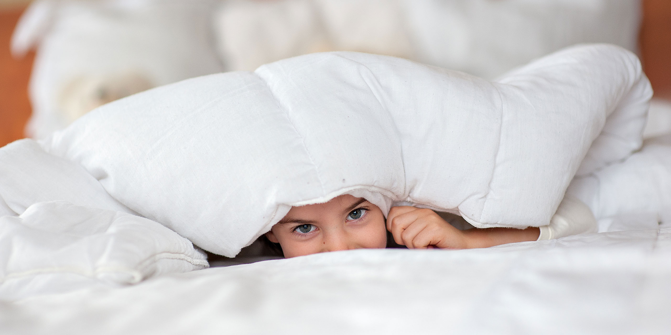 Little Girl in Hotel Bed; Courtesy of Lena Dyomina/Shutterstock.com