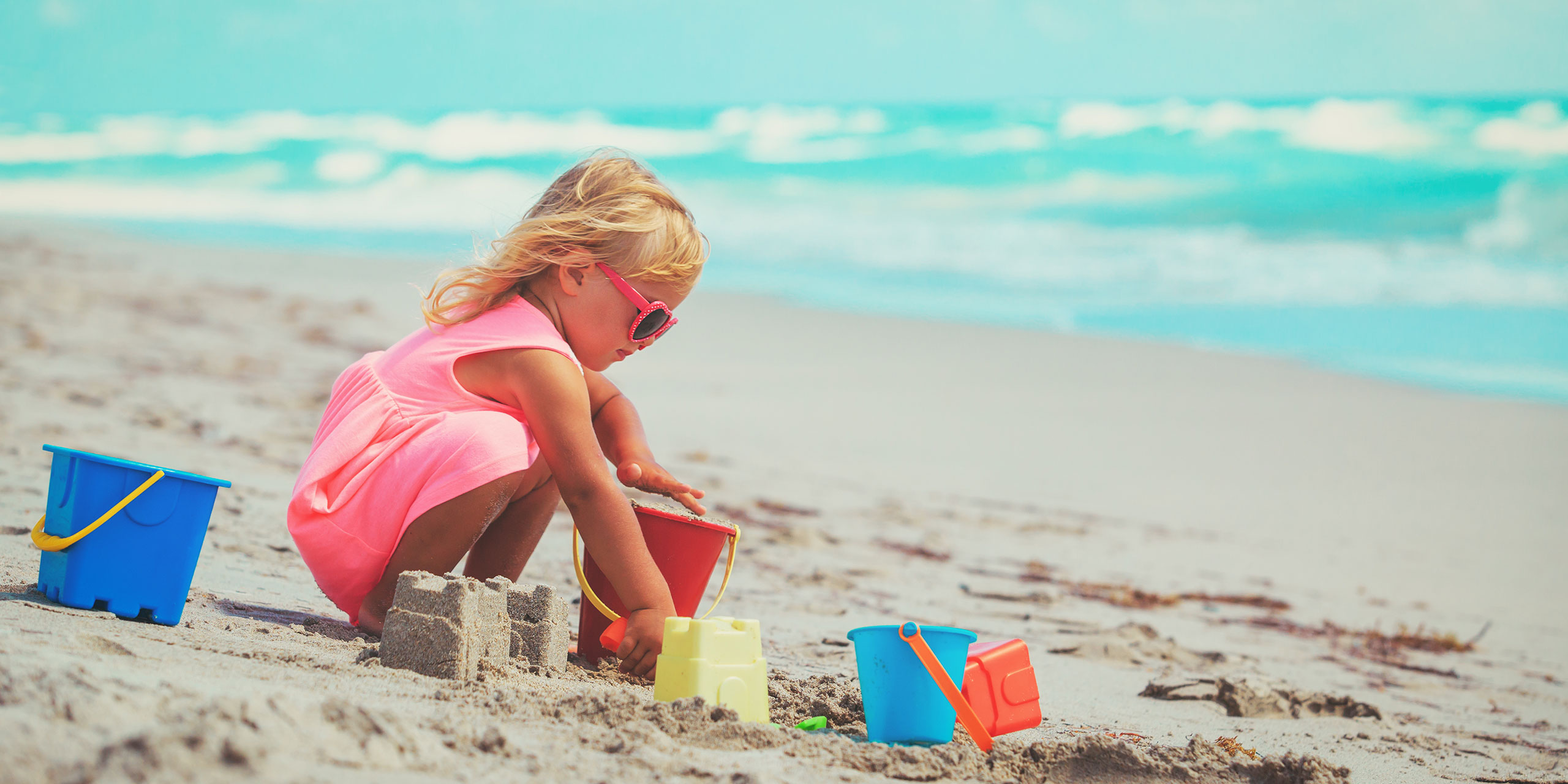 Little Girl Playing with Sand Toys on the Beach;NadyaEugene/Shutterstock.com