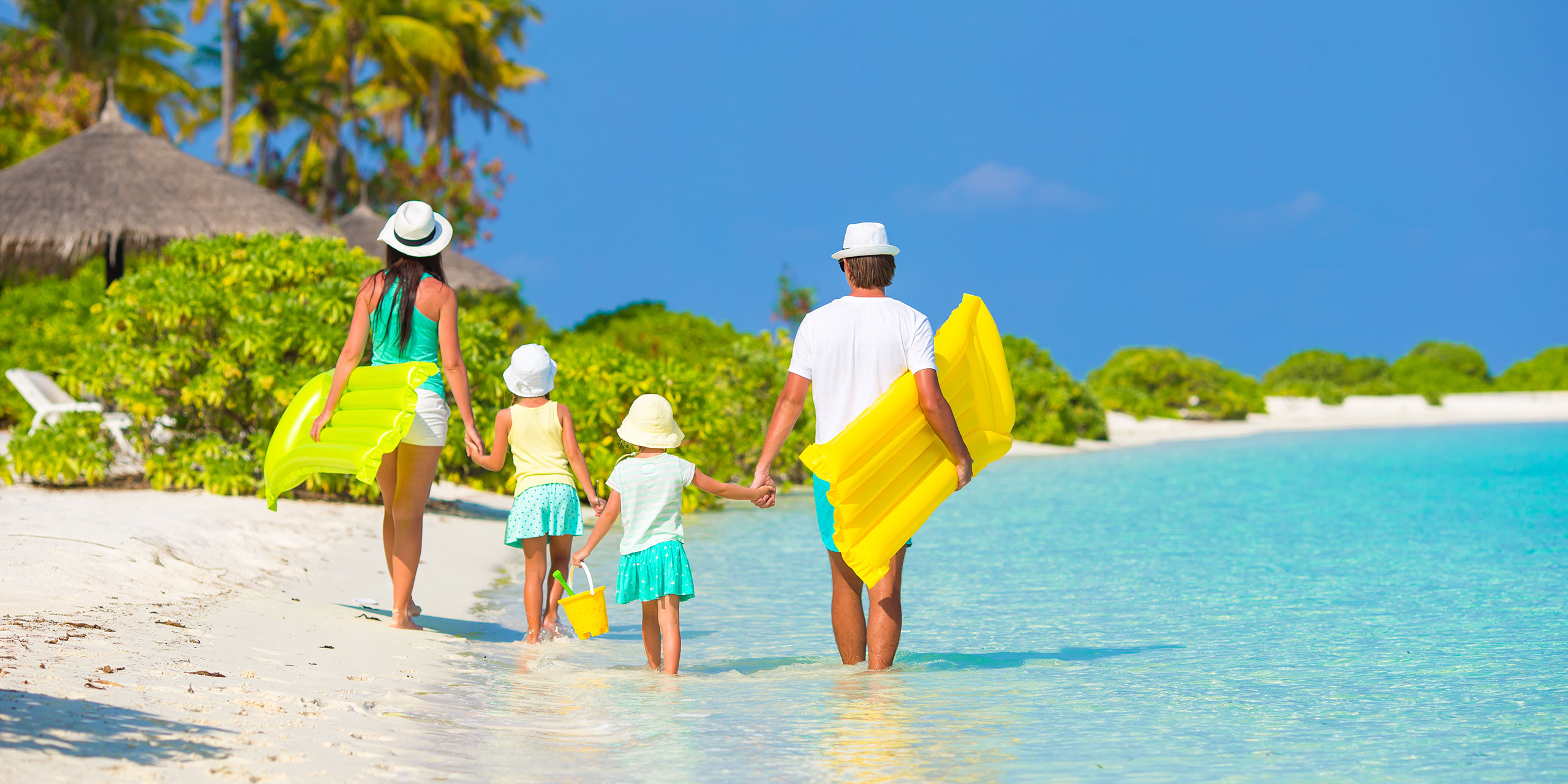 Family Walking on Caribbean Beach; Courtesy of TravnikovStudio/Shutterstock.com