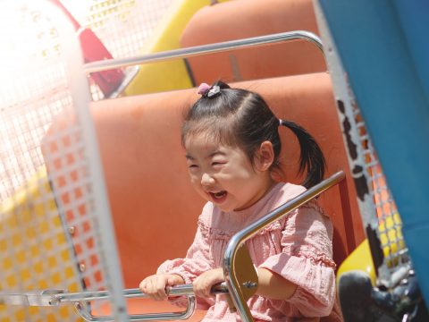Young Asian Girl on Amusement Park Ride; Courtesy of Hans P./Shutterstock.com