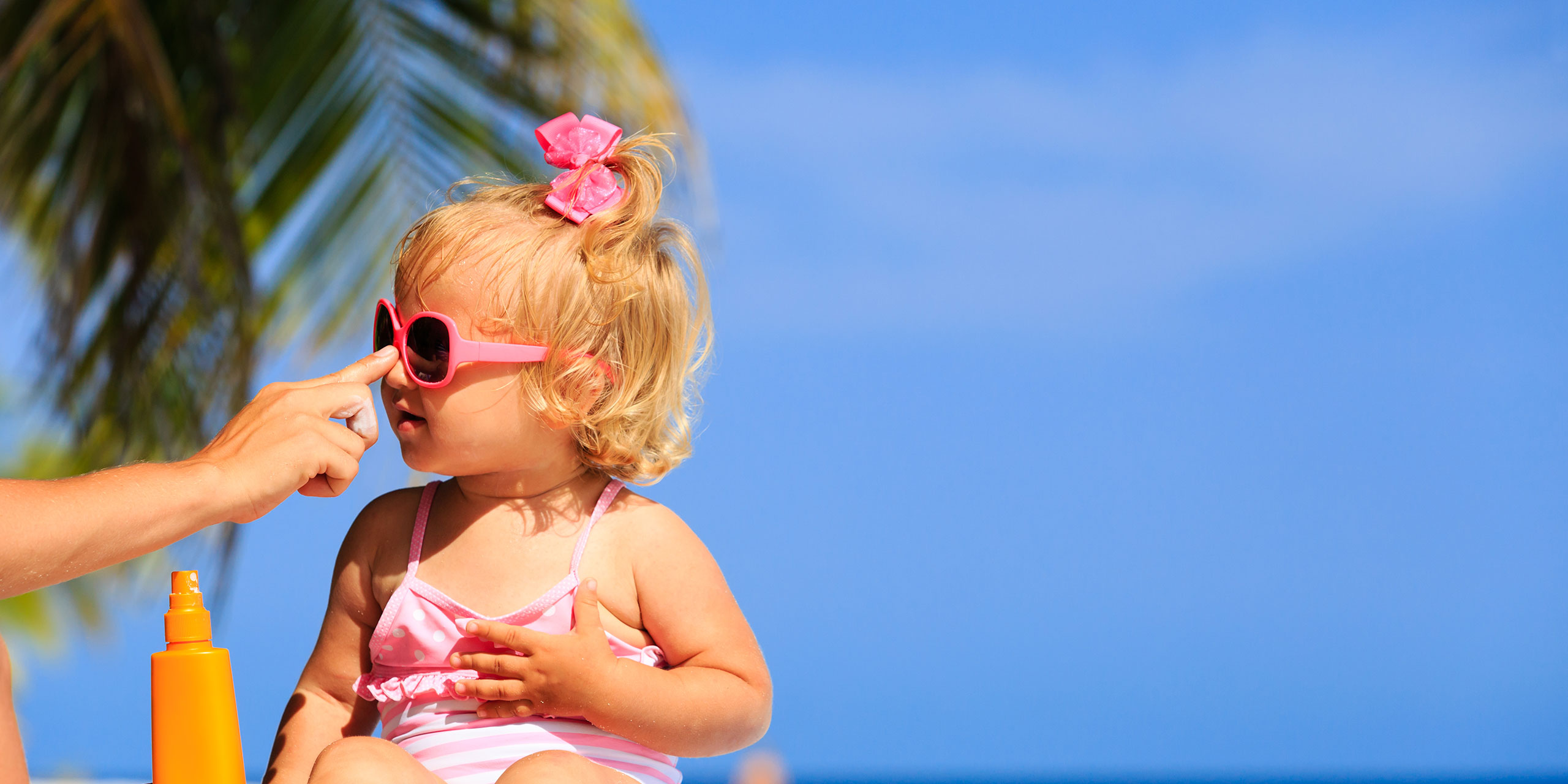 Baby Getting Sunscreen Applied; Courtesy of NadyaEugene/Shutterstock.com