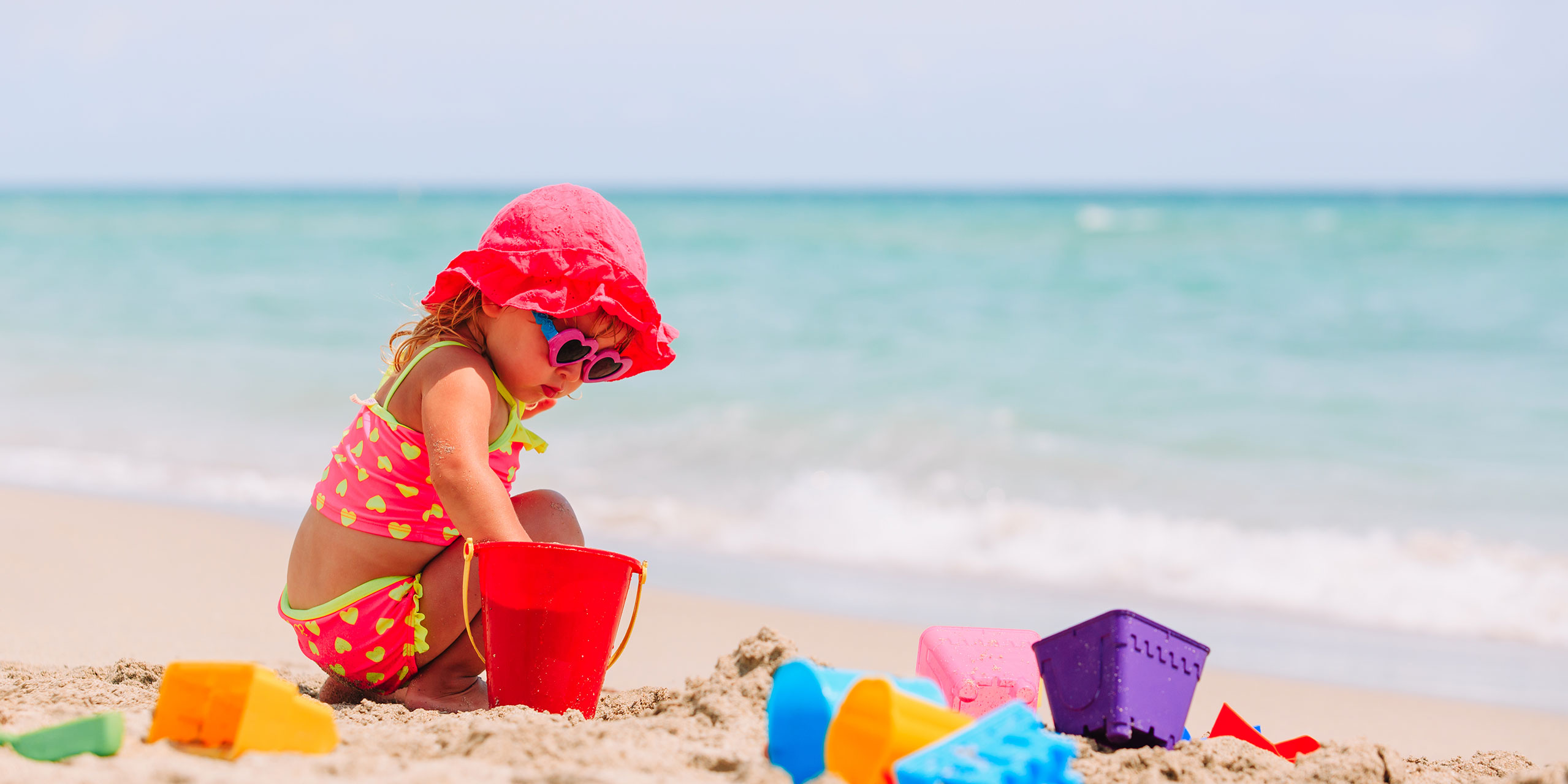 Little Girl Playing on Beach; Courtesy of NadyaEugene/Shutterstock.com