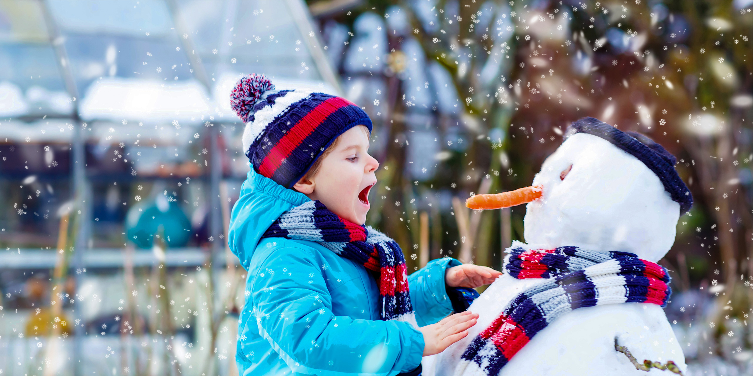 little kid boy making a snowman and eating carrot. child playing and having fun with snow on cold day.; Courtesy of Romrodphoto/Shutterstock
