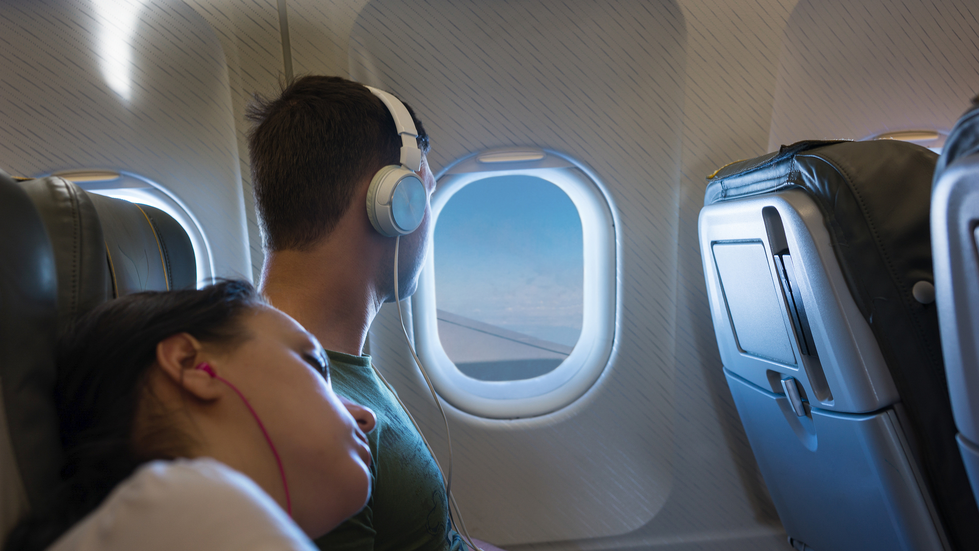 Couple on night flight looking out window